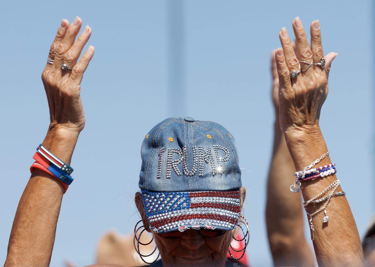 Supporters of former President and current Republican candidate for president Donald Trump pray at the start of a rally in Wilmington, N.C. on Saturday, Sept. 21, 2024.