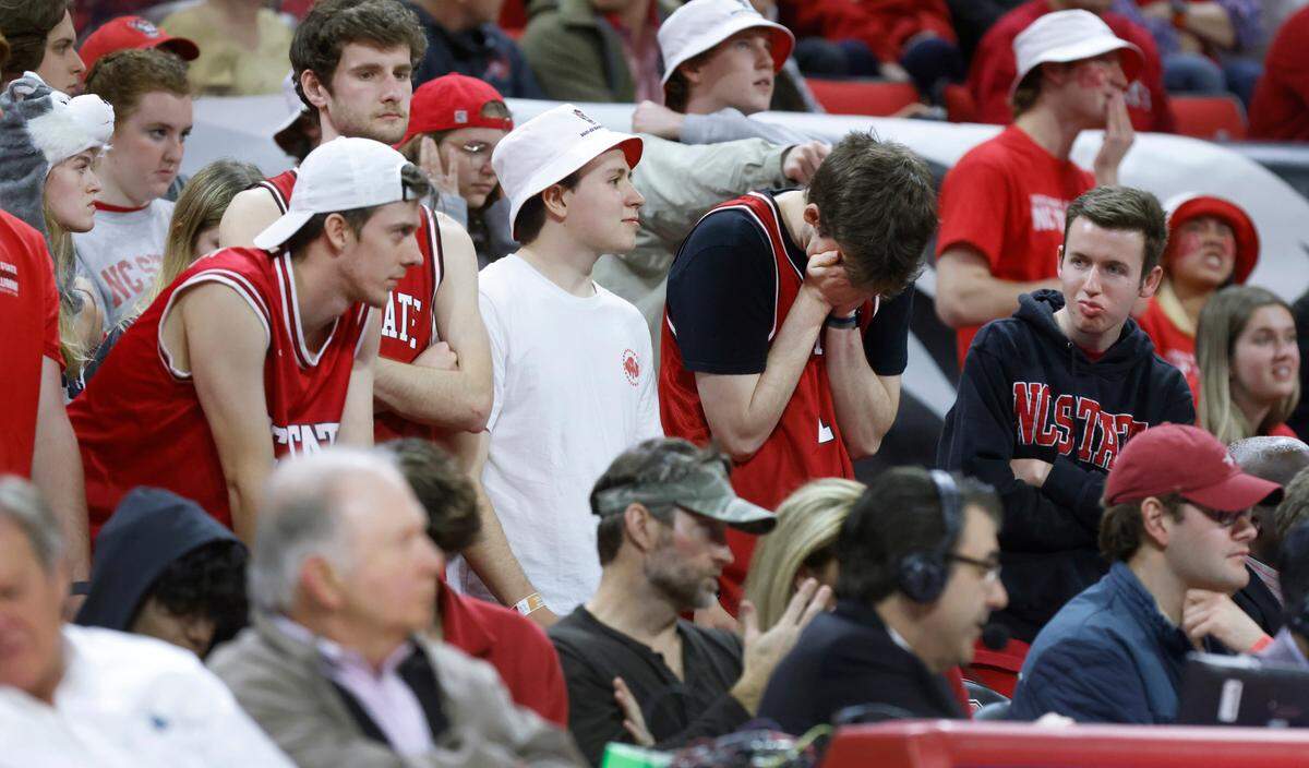 Wolfpack fans react after North Carolina’s Caleb Love made the basket while being fouled during the second half of UNC’s 84-74 victory over N.C. State at PNC Arena in Raleigh, N.C., Saturday, Feb. 26, 2022.