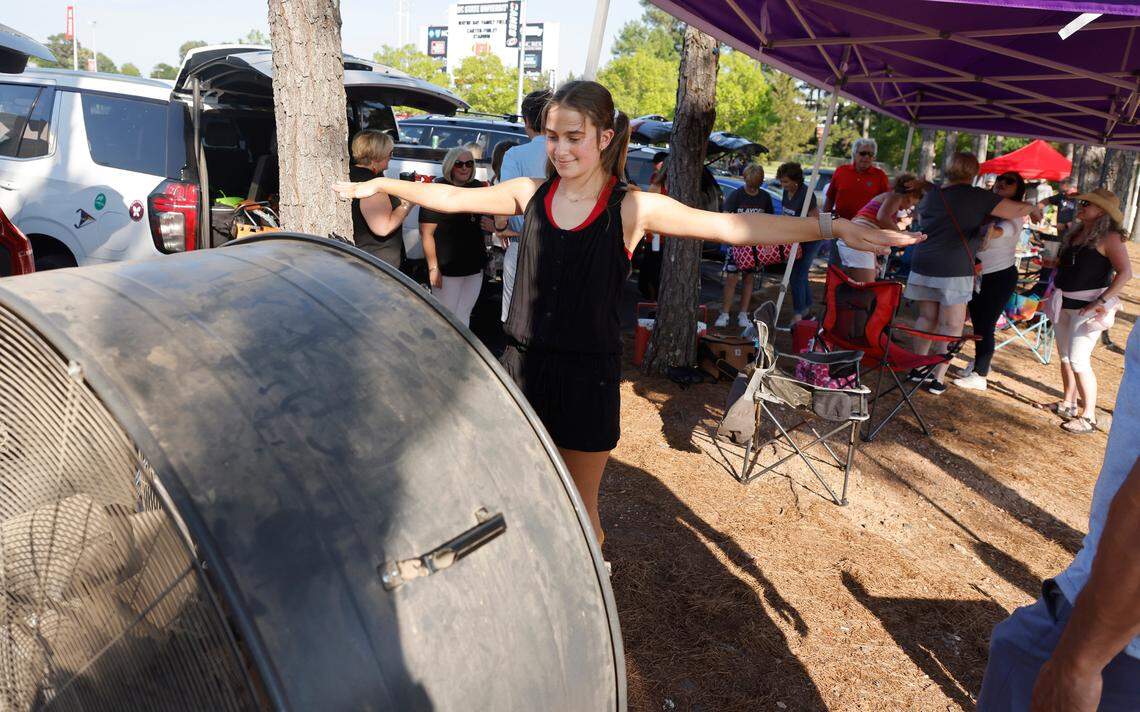 Alexandria Corcoran, 11, keeps cool with a 48-inch shop fan as Carolina Hurricanes fans tailgate before the Canes’ playoff game against the N.Y. Rangers at PNC Arena Friday, May 20, 2022.