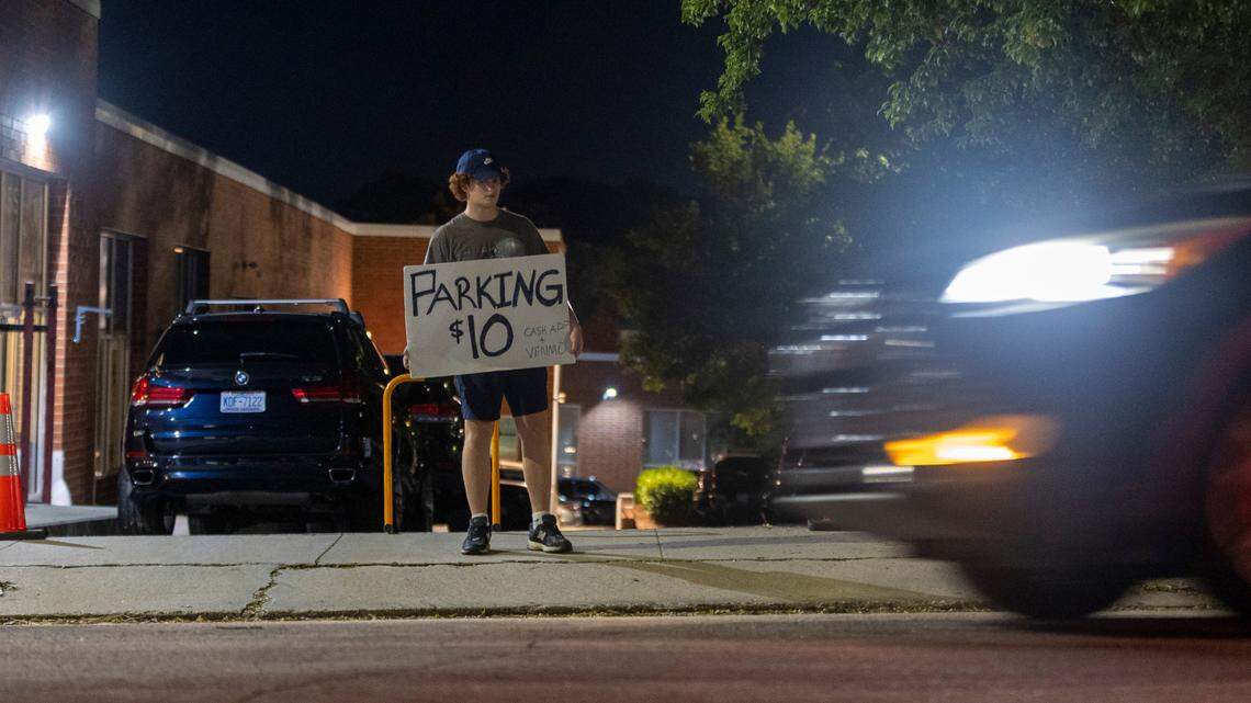 Seventeen-year-old Byron Ryan manages the parking lot of a family business on North Street offering parking for Glenwood South visitors at a flat $10 rate on Friday July 21, 2023 in Raleigh, N.C.