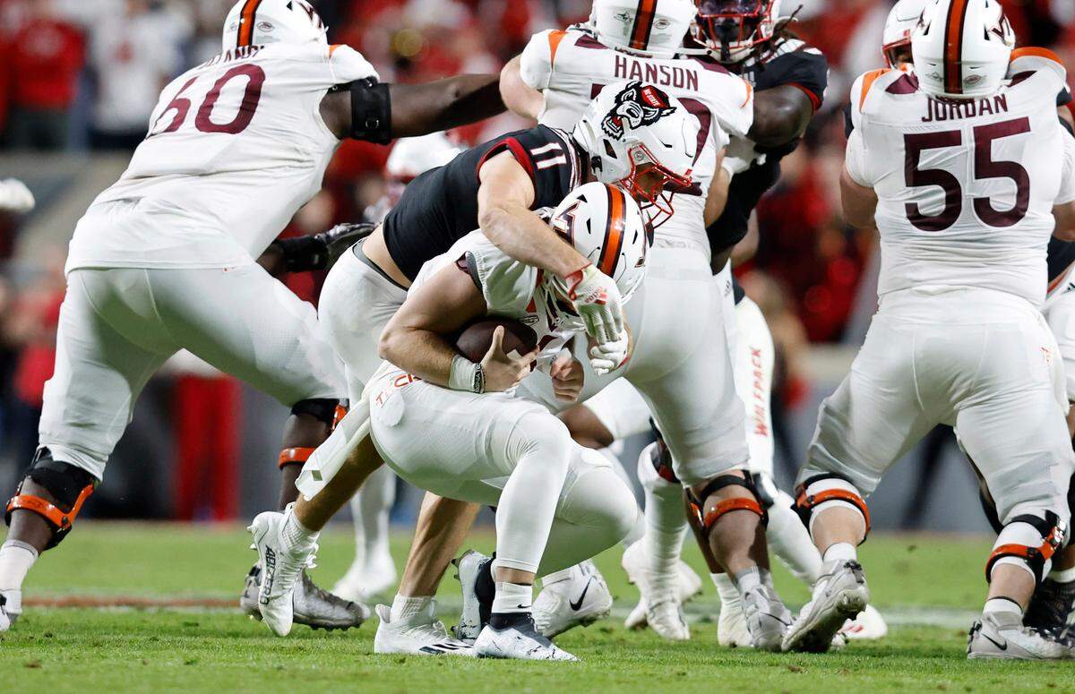 N.C. State linebacker Payton Wilson (11) sacks Virginia Tech quarterback Grant Wells (6) during the first half of N.C. State’s game against Virginia Tech at Carter-Finley Stadium in Raleigh, N.C., Thursday, Oct. 27, 2022.
