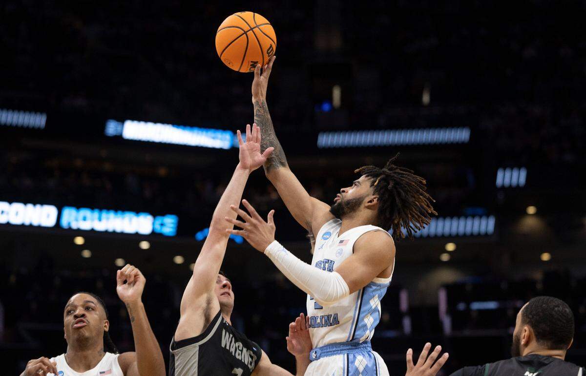 North Carolina’s R.J. Davis (4) puts up a shot against Wagner’s Javier Ezquerra (1) in the second half on Thursday, March 21, 2024 during the NCAA Tournament at Spectrum Center in Charlotte, N.C. Davis led all scores with 22 points in the Tar Heels’ 90-62 victory.