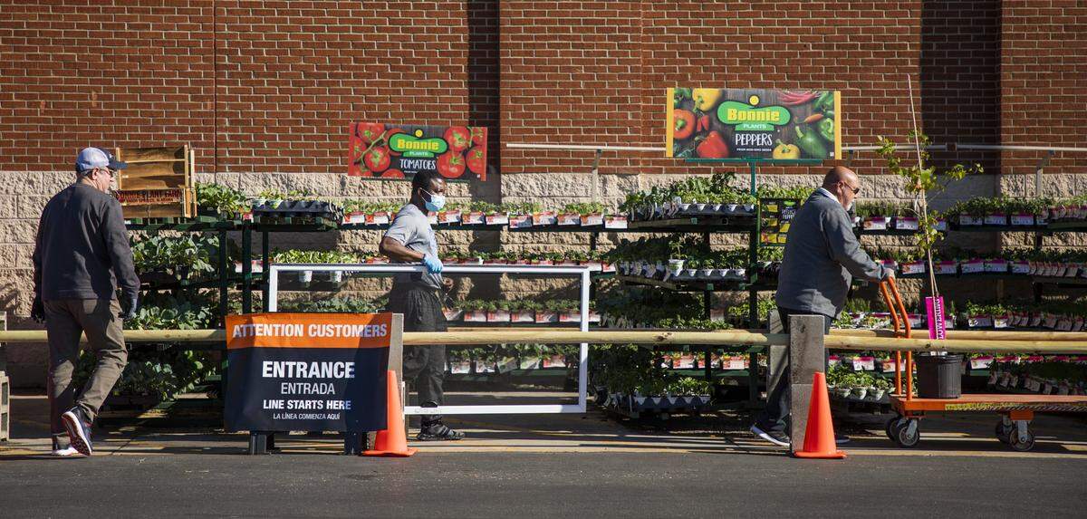 Customers maintain their distance while lining up to enter Home Depot on Saturday, Apr. 4, 2020, in Durham, N.C. Starting at 5 p.m., a combined and revised ‘stay-at-home’ order by the City of Durham and Durham County Government will take effect, including reducing allowed group gatherings from 10 people to five.