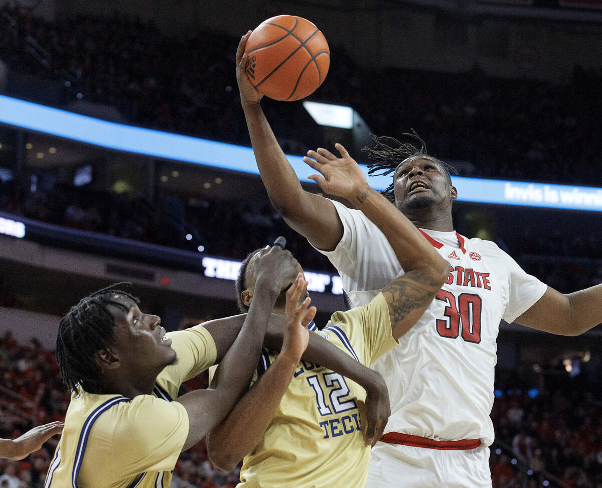 N.C. State’s DJ Burns Jr. battles for a rebound with Georgia Tech’s Baye Ndongo and Tyzhaun Claude during the first half of the Wolfpack’s game on Saturday, Feb. 3, 2024, at PNC Arena in Raleigh, N.C.