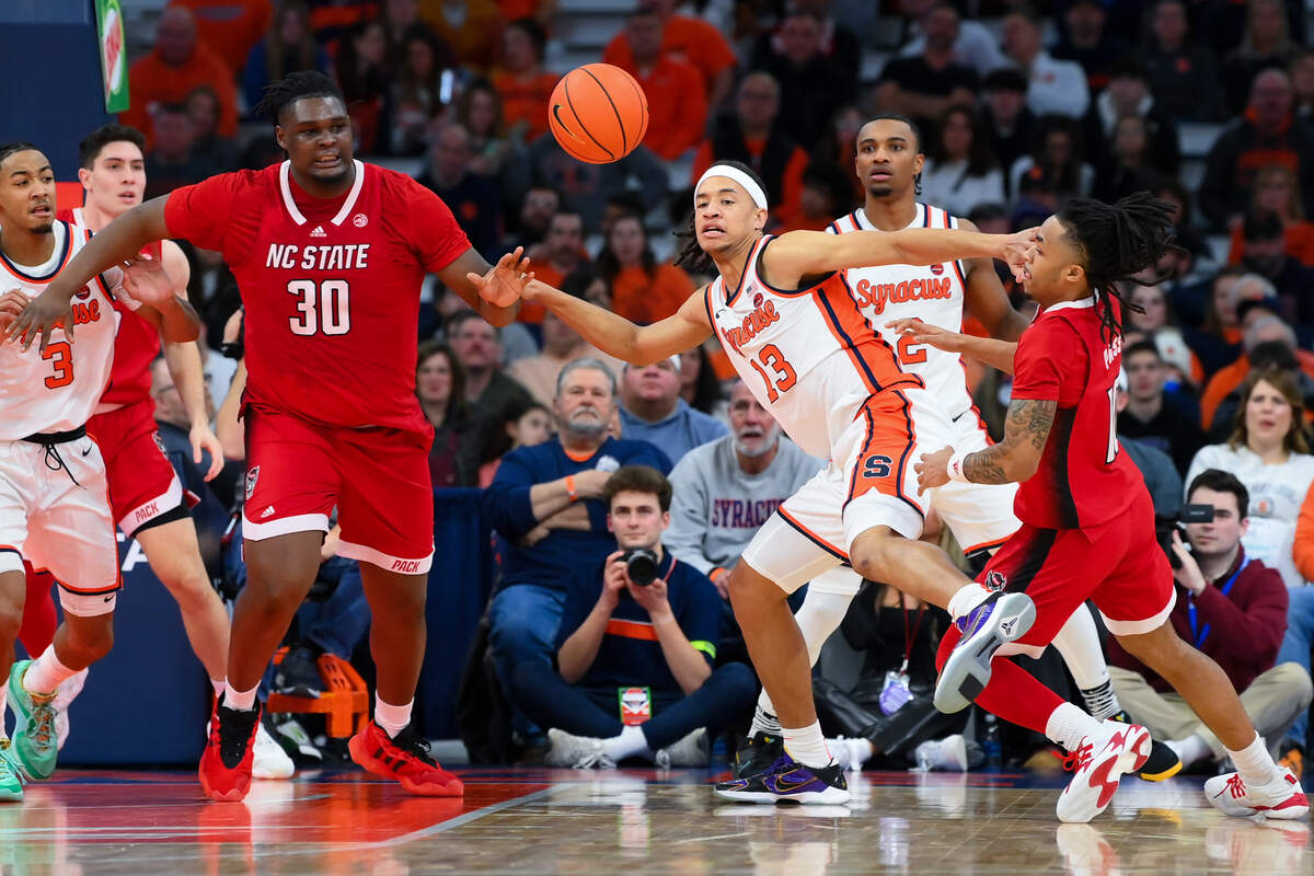 Jan 27, 2024; Syracuse, New York, USA; North Carolina State Wolfpack forward DJ Burns Jr. (30) and Syracuse Orange forward Benny Williams (13) and North Carolina State Wolfpack guard Breon Pass (10) react to a loose ball during the second half at the JMA Wireless Dome. Mandatory Credit: Rich Barnes-USA TODAY Sports