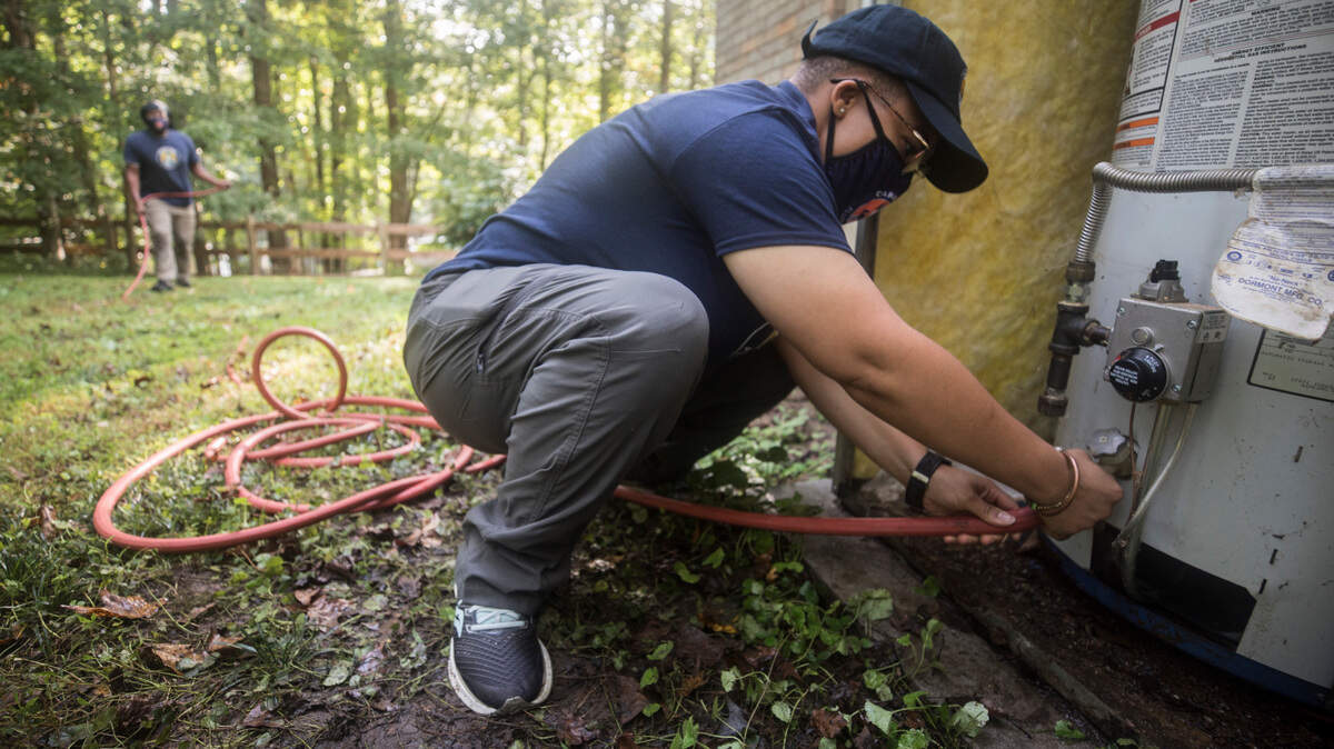 Jasmine Jones works on a water heater at a home in Durham, N.C., on Tuesday, Sept. 29, 2020.