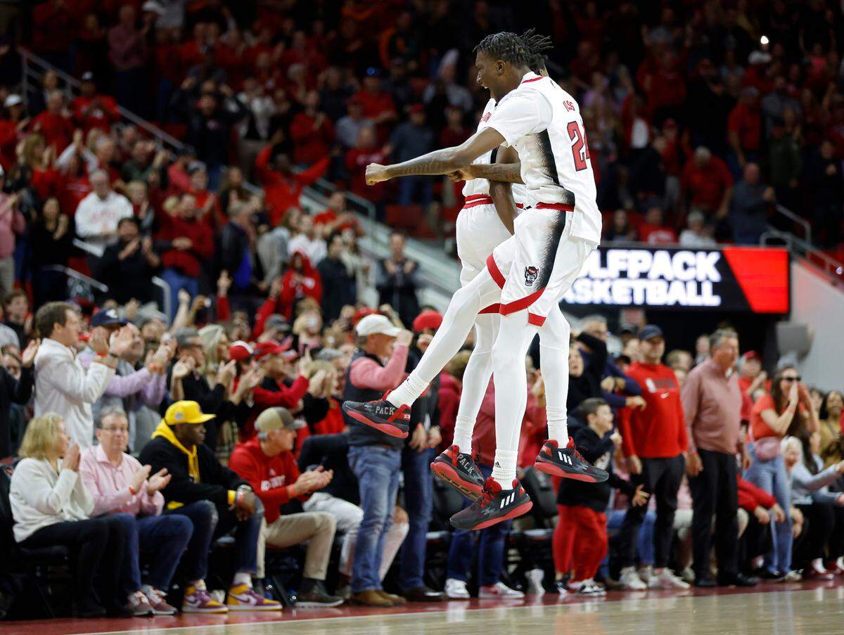 N.C. State’s Terquavion Smith and Ernest Ross celebrate following a Miami turnover in the closing seconds of overtime at PNC Arena on Saturday, Jan. 14, 2023, in Raleigh, N.C.
