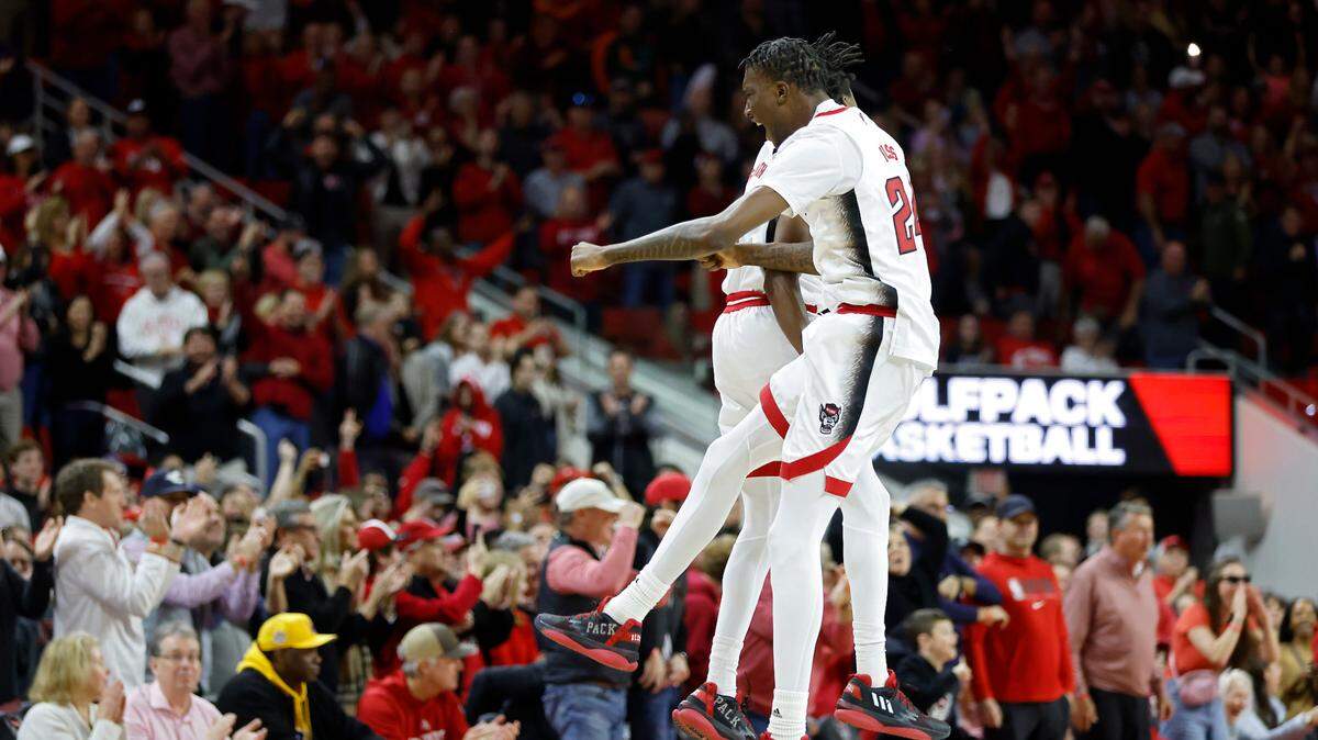 N.C. State’s Terquavion Smith and Ernest Ross celebrate following a Miami turnover in the closing seconds of overtime at PNC Arena on Saturday, Jan. 14, 2023, in Raleigh, N.C.