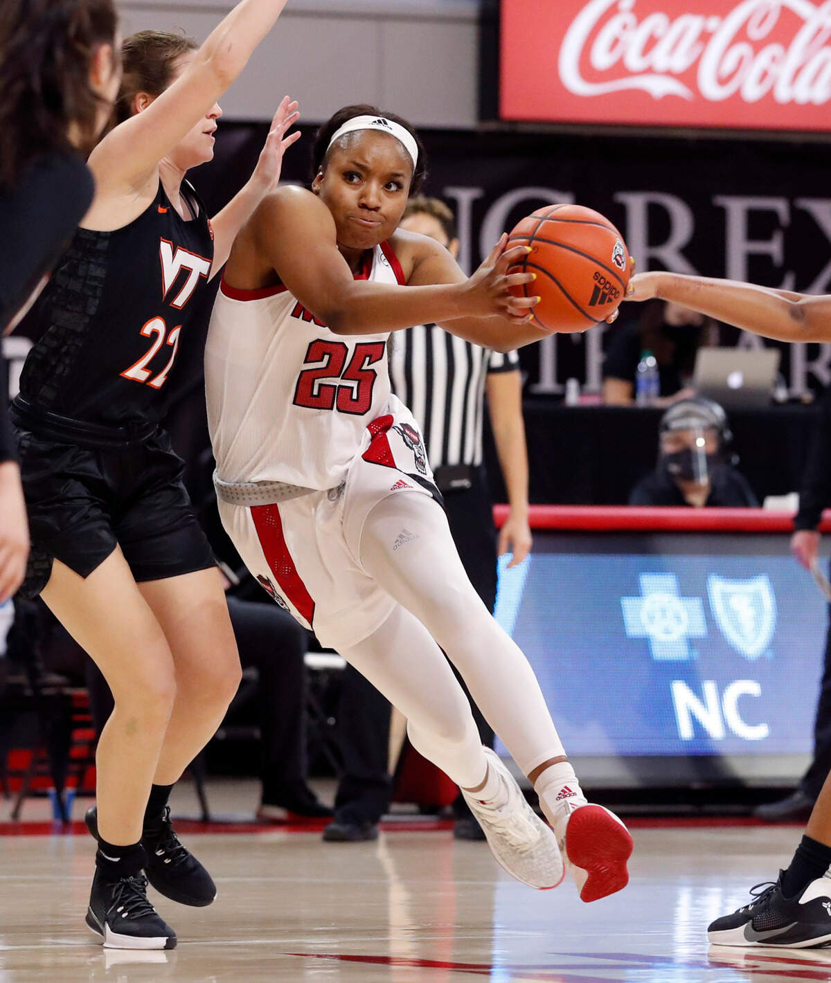 N.C. State’s Kayla Jones (25) drives around Virginia Tech’s Cayla King (22) during the second half of N.C. State’s 89-87 victory over Virginia Tech at Reynolds Coliseum in Raleigh, N.C., Sunday, January 24, 2021.