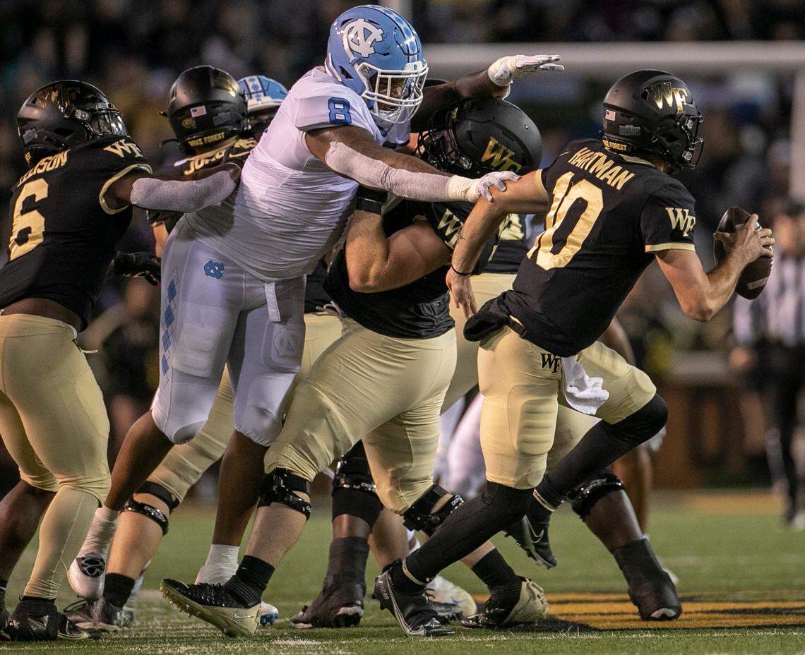Wake Forest quarterback Sam Hartman (10) is pressured by North Carolina’s Myles Murphy (8) in the first quarter on Saturday, November 12, 2022 at Truist Field in Winston-Salem, N.C.
