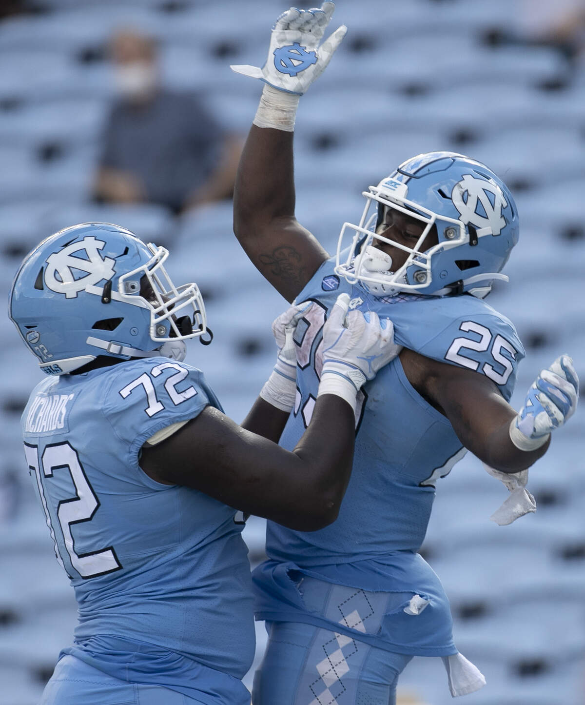 North Carolina’s Asim Richards (72) celebrates with Javonte Williams (25) after a 27-yard touchdown run in the fourth quarter to give the Tar Heels’ a 45-14 lead over N.C. State in the fourth quarter at Kenan Stadium on Saturday, October 24, 2020 in Chapel Hill, N.C.