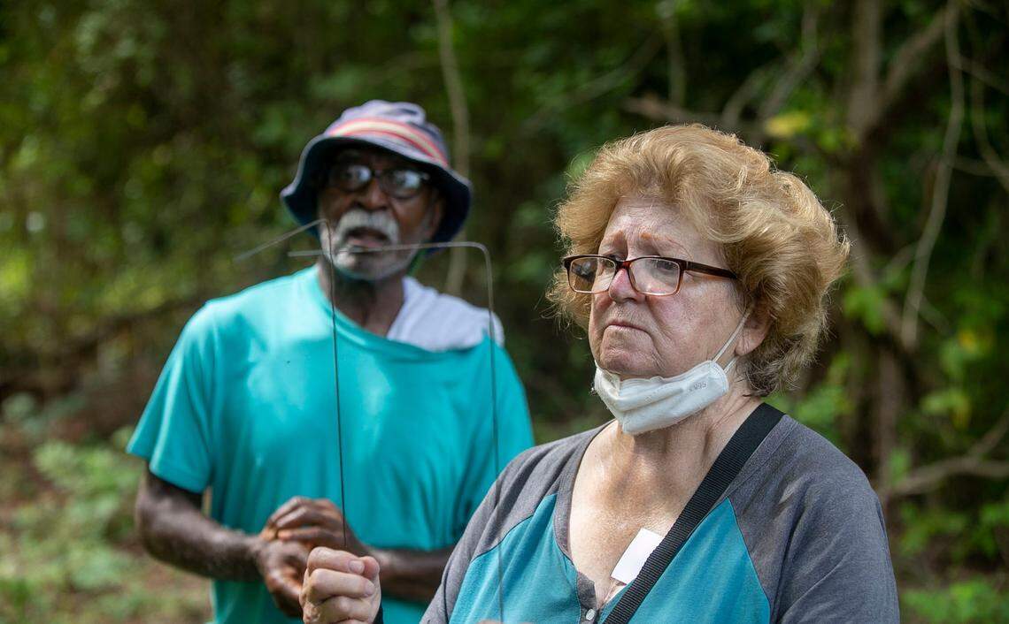 Joy Williams uses divining rods to locate graves in Wilkins Cemetery, one of the oldest African-American cemeteries in Harnett County, on Wednesday, August 24, 2022 in Dunn, N.C.