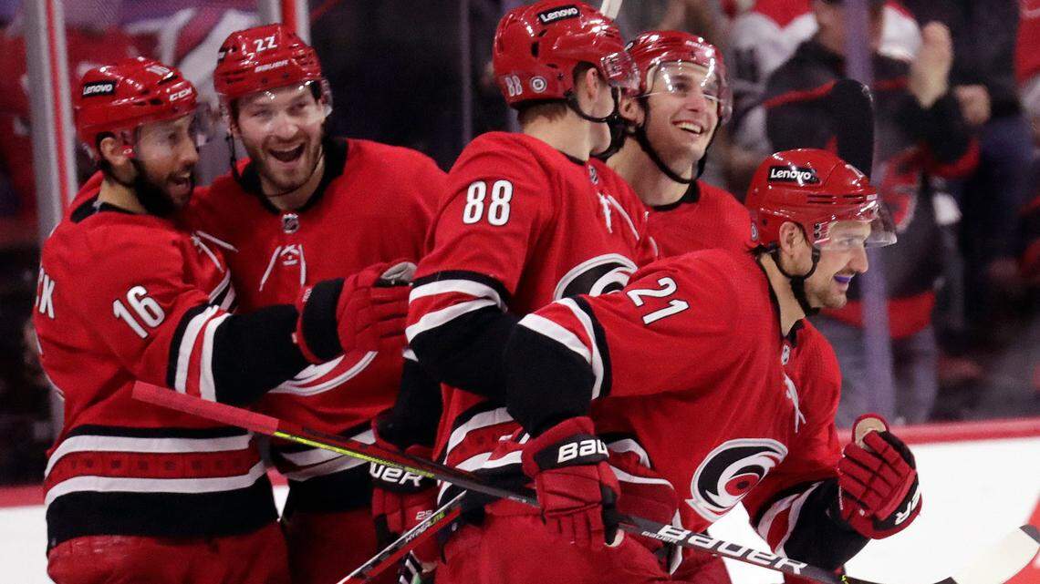Carolina Hurricanes right wing Nino Niederreiter (21) celebrates his second goal of the night with teammates center Vincent Trocheck (16), defenseman Brett Pesce, second from left, Martin Necas (88) and defenseman Tony DeAngelo, second from right, during the third period of an NHL hockey game against the Detroit Red Wings, Thursday, Dec. 16, 2021, in Raleigh, N.C. (AP Photo/Chris Seward)