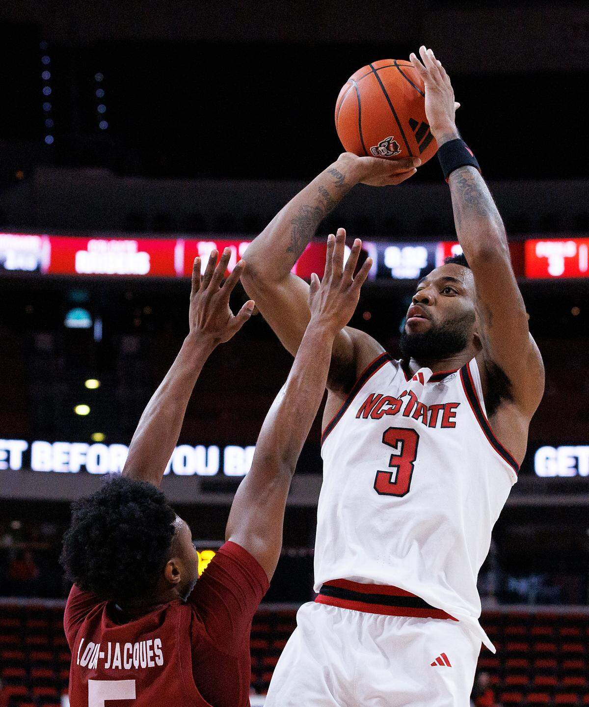 N.C. State’s Dontrez Styles shoots over Colgate’s Nicolas Louis-Jacques during the first half of the Wolfpack’s 72-49 win at Lenovo Center on Monday, Nov. 18, 2024, in Raleigh, N.C.