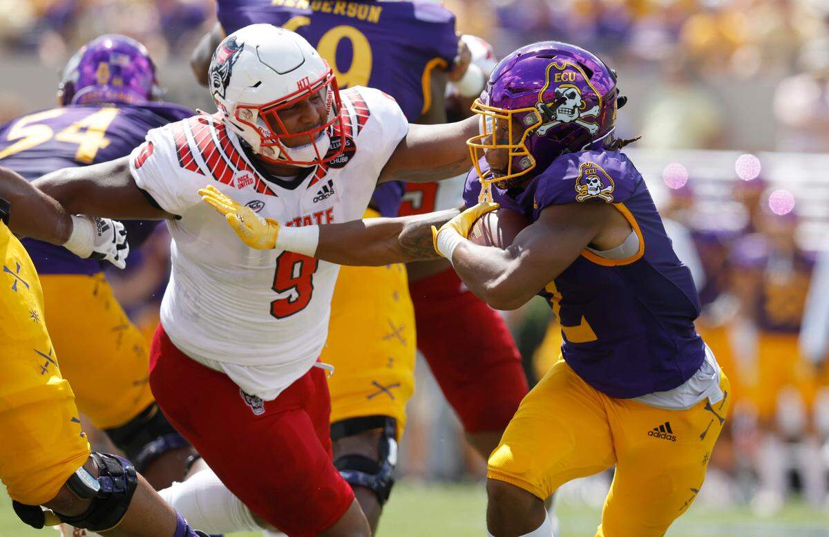 N.C. State defensive end Savion Jackson (9) comes in to stop East Carolina running back Keaton Mitchell (2) during the first half of N.C. State’s game against ECU at Dowdy-Ficklen Stadium in Greenville, N.C., Saturday, Sept. 3, 2022.