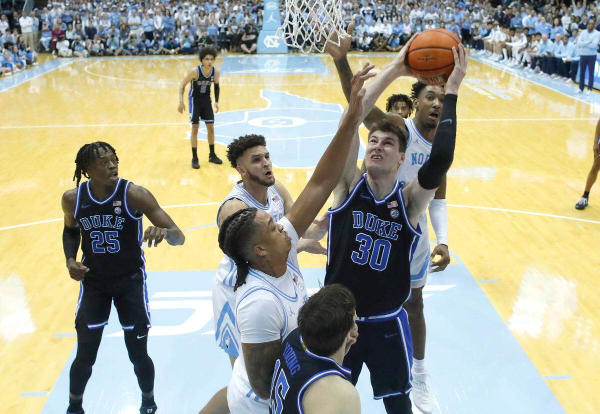 Duke’s Kyle Filipowski (30) heads to the basket as North Carolina’s Armando Bacot (5), Pete Nance (32) andLeaky Black (1) defend during Duke’s 62-57 victory over UNC at the Smith Center in Chapel Hill, N.C., Saturday, March 4, 2023.