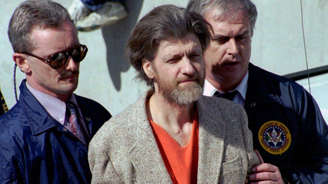 In this April 4, 1996 file photo, Ted Kaczynski, better known as the Unabomber, is flanked by federal agents as he is led to a car from the federal courthouse in Helena, Mont. He was found dead Saturday in a prison in Butner, North Carolina.