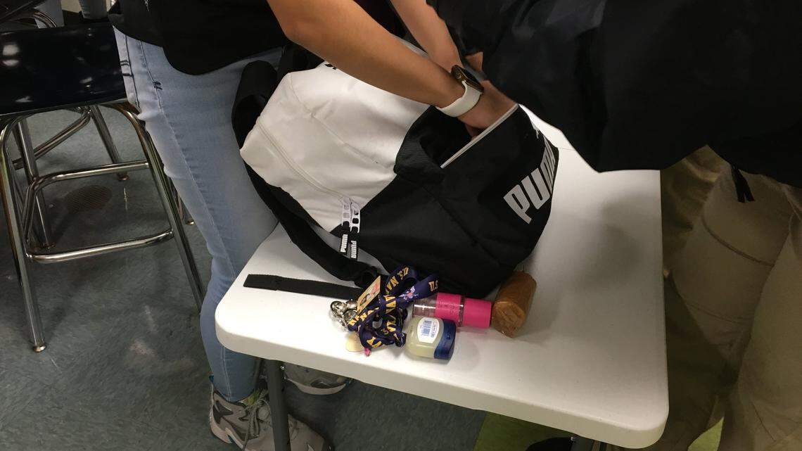 A Rocky River High School student in Mint Hill, N.C., removes items from a book bag during a gun search on Jan. 29, 2019.