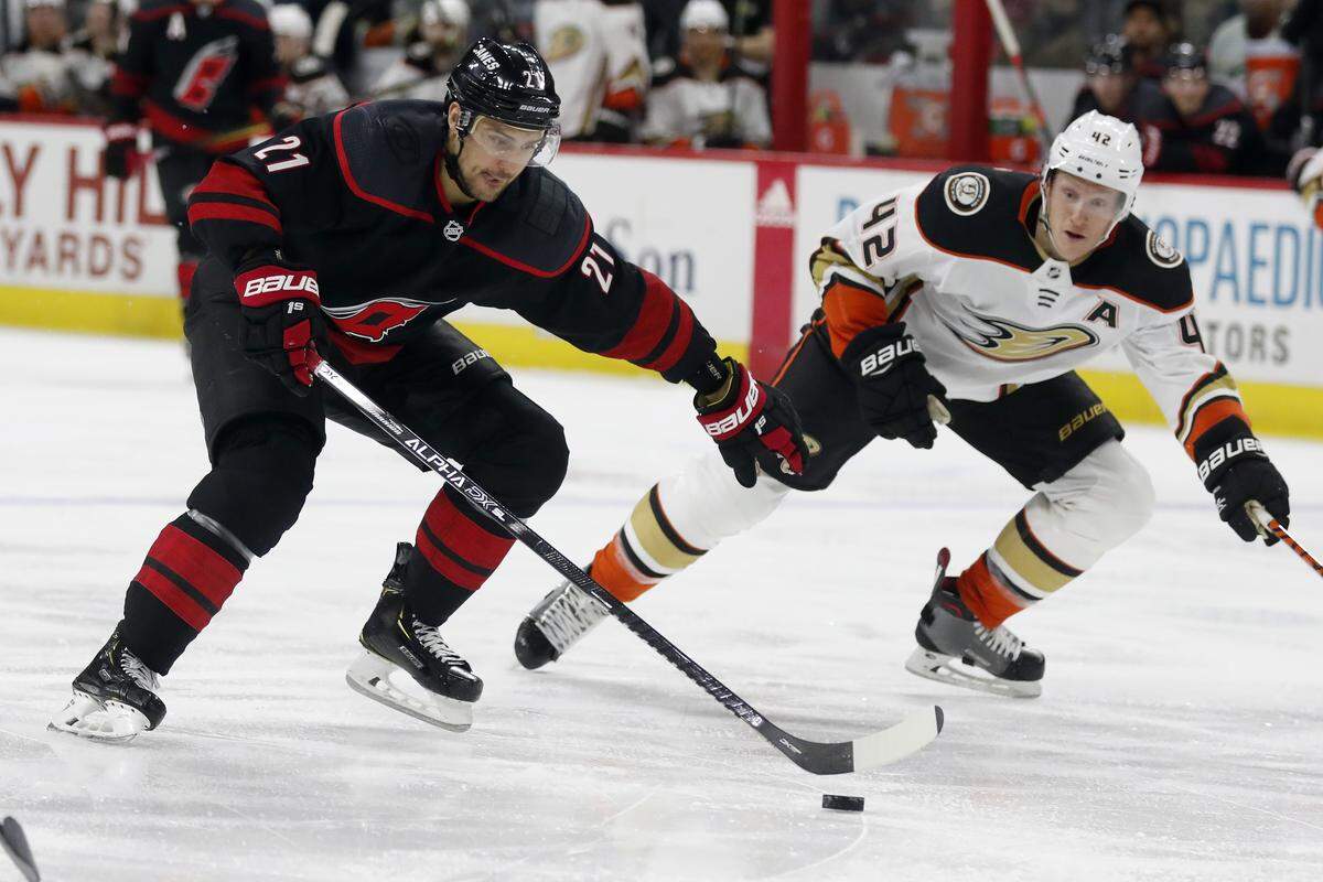Carolina Hurricanes right wing Nino Niederreiter (21) skates against Anaheim Ducks defenseman Josh Manson (42) during the second period of an NHL hockey game in Raleigh, N.C., Friday, Jan. 17, 2020. (AP Photo/Gerry Broome)