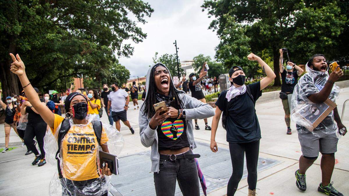 People cheer as Black Lives Matter demonstrators ride on horseback through downtown Raleigh Friday, June 19, 2020 in recognition of Juneteenth.