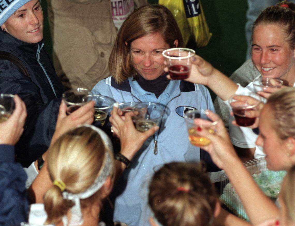 UNC field Hockey coach, Karen Shelton (center, Carolina blue jacket), gets a toast from her team, marking her 300th win at Carolina, after beating Wake Forest in 1998. The toast was made with grape juice.