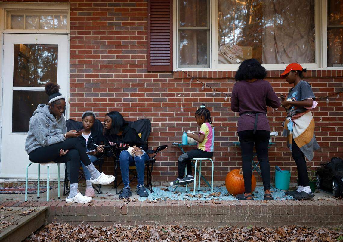 From left, sisters Ahava, 16, Abby, 12, Sarah, 15, Hannah, 5, and Chiyrah, 19, relax on the porch with their mother, Sheba Everett, at their home in Durham, N.C. on Thursday, Nov. 3, 2022.