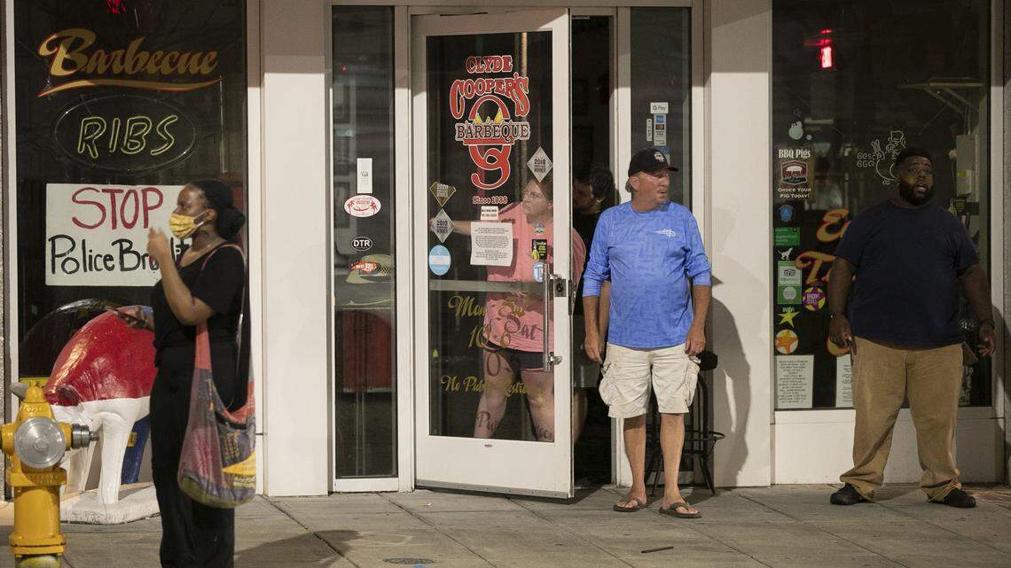 Clyde Cooper’s Barbeque owner Randy Holt stands in front of his business in the early morning hours of Sunday, May 31, 2020, protecting his business from vandals and looters after demonstrators damaged most businesses in downtown after a night of violence and clashes with police. The restaurant will reopen Oct. 14 for the first time since the beginning of the pandemic.