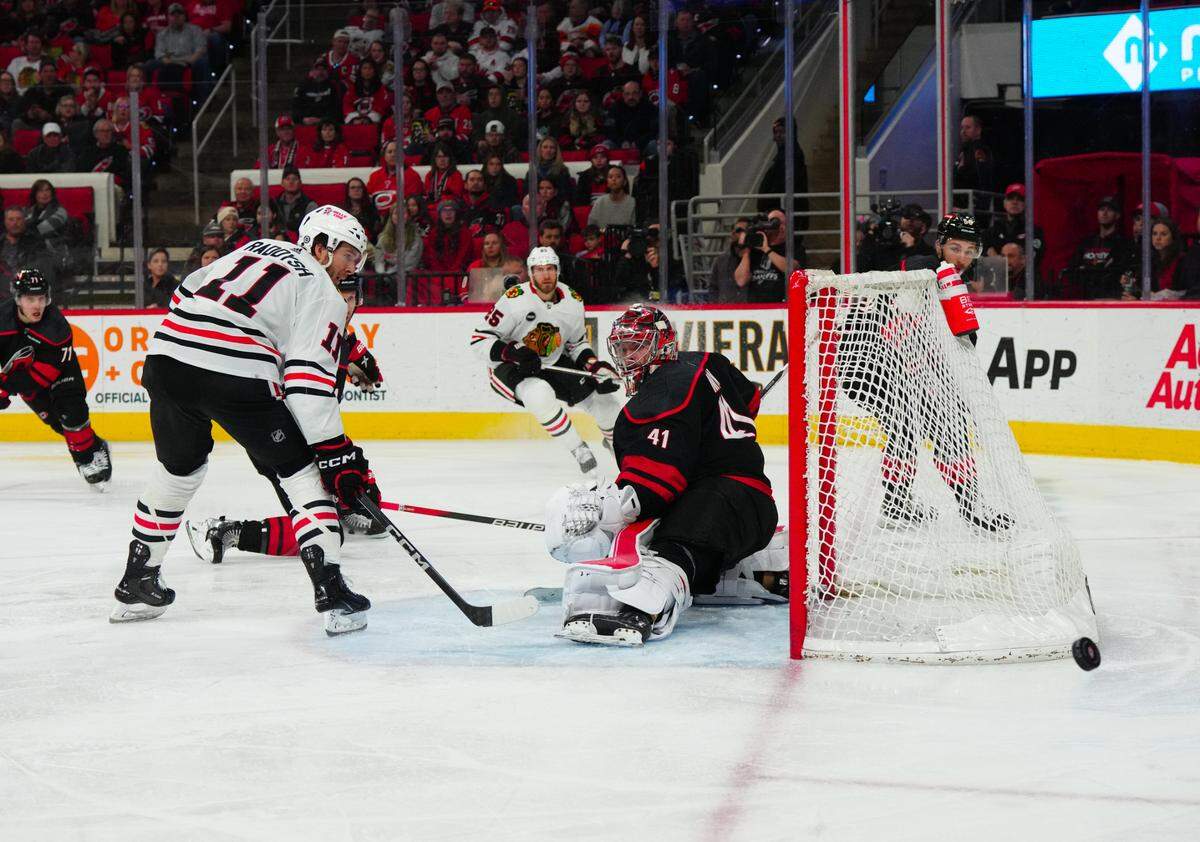 Feb 19, 2024; Raleigh, North Carolina, USA; Chicago Blackhawks right wing Taylor Raddysh (11) misses his tip attempt against Carolina Hurricanes goaltender Spencer Martin (41) during the second period at PNC Arena. Mandatory Credit: James Guillory-USA TODAY Sports