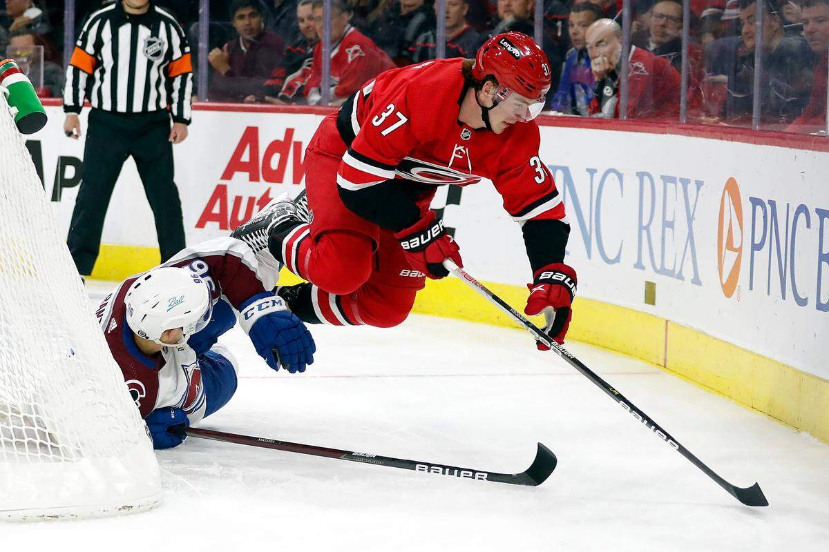 Carolina Hurricanes’ Andrei Svechnikov (37) is knocked off his skates by Colorado Avalanche’s Mikko Rantanen (96) during the first period of an NHL hockey game in Raleigh, N.C., Thursday, March 10, 2022. (AP Photo/Karl B DeBlaker)