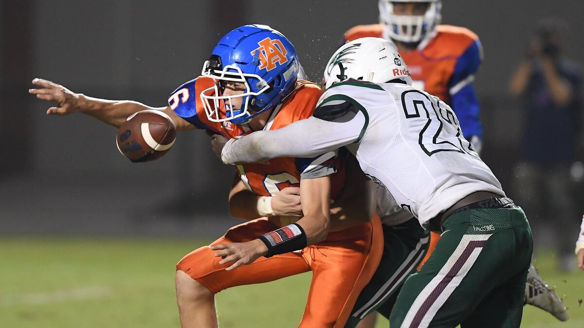Duke Carroll (16) of Athens Drive fumbles the ball against pressure from Tyre Pritchett, right, of Green Hope. The Green Hope Falcons visited the Athens Drive Jaguars in a high school football game on October 15, 2018. Green Hope won 33-9.