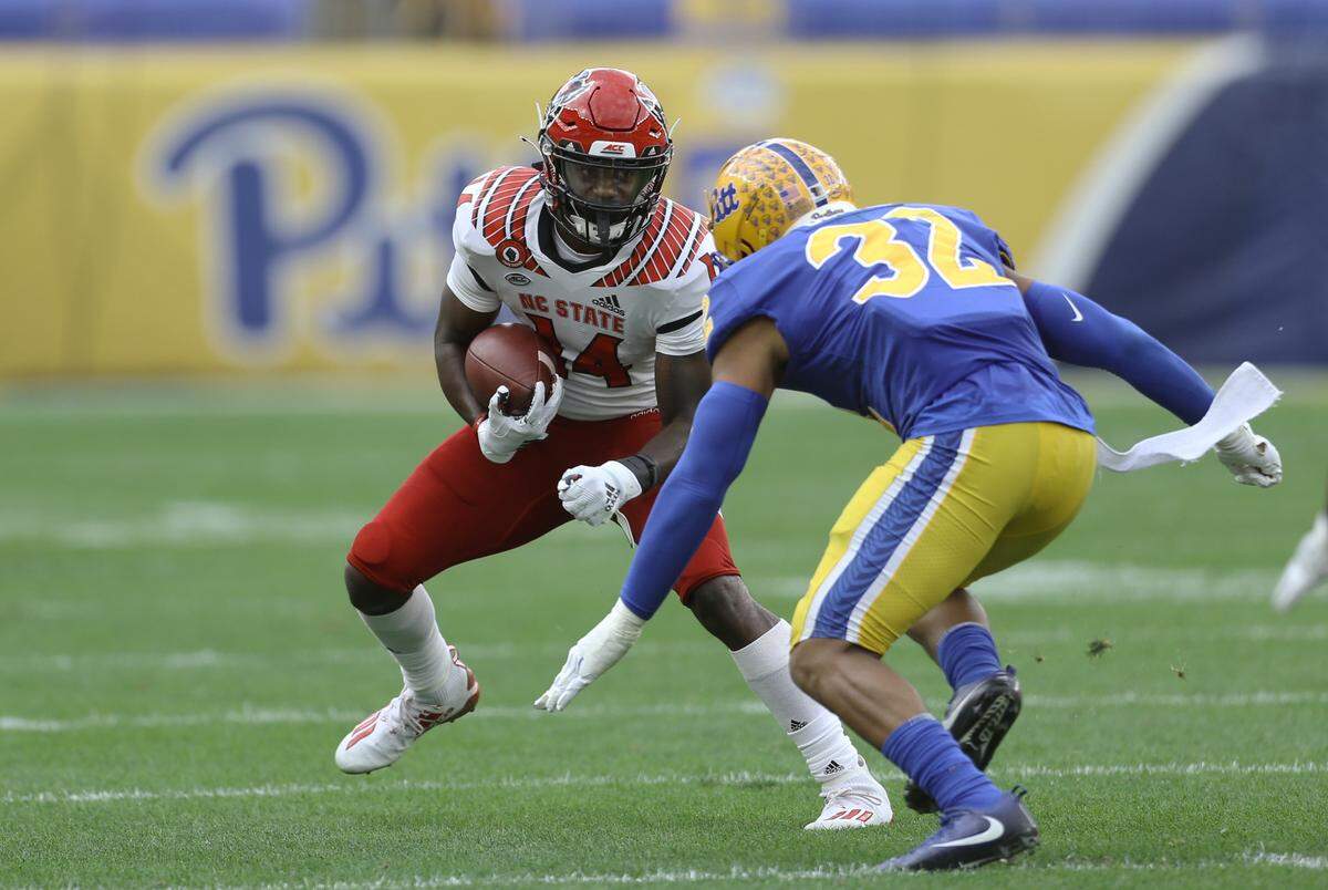 N.C. State’s Porter Rooks (14) runs after a catch as Pittsburgh Panthers linebacker SirVocea Dennis (32) defends during the second quarter at Heinz Field.