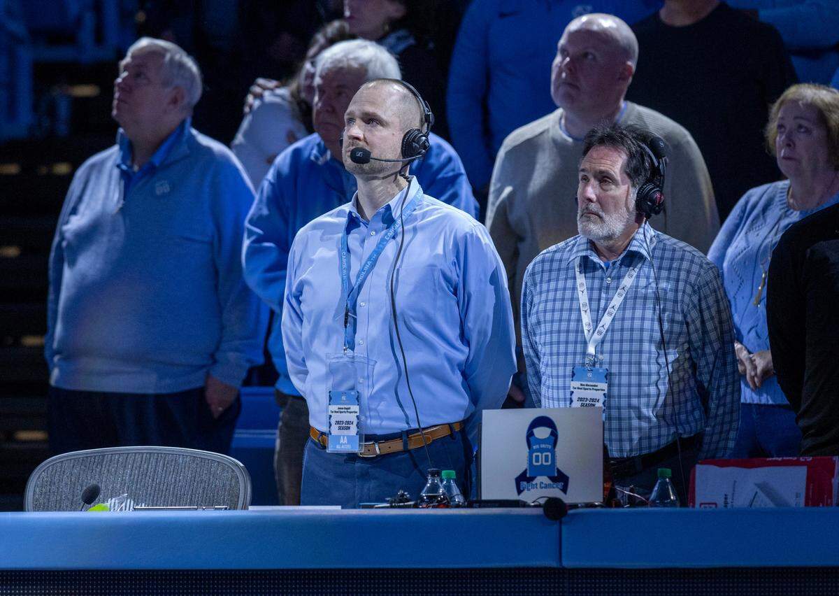 Tar Heel Sports Network announcer Jones Angell stands next to an empty chair during a tribute Eric Montross prior to the North Carolina vs Charleston Southern game on Friday, December 29, 2023 at the Smith Center in Chapel Hill, N.C. Montross who played at North Carolina and was a color commentator, died of cancer on December 17, 2023.