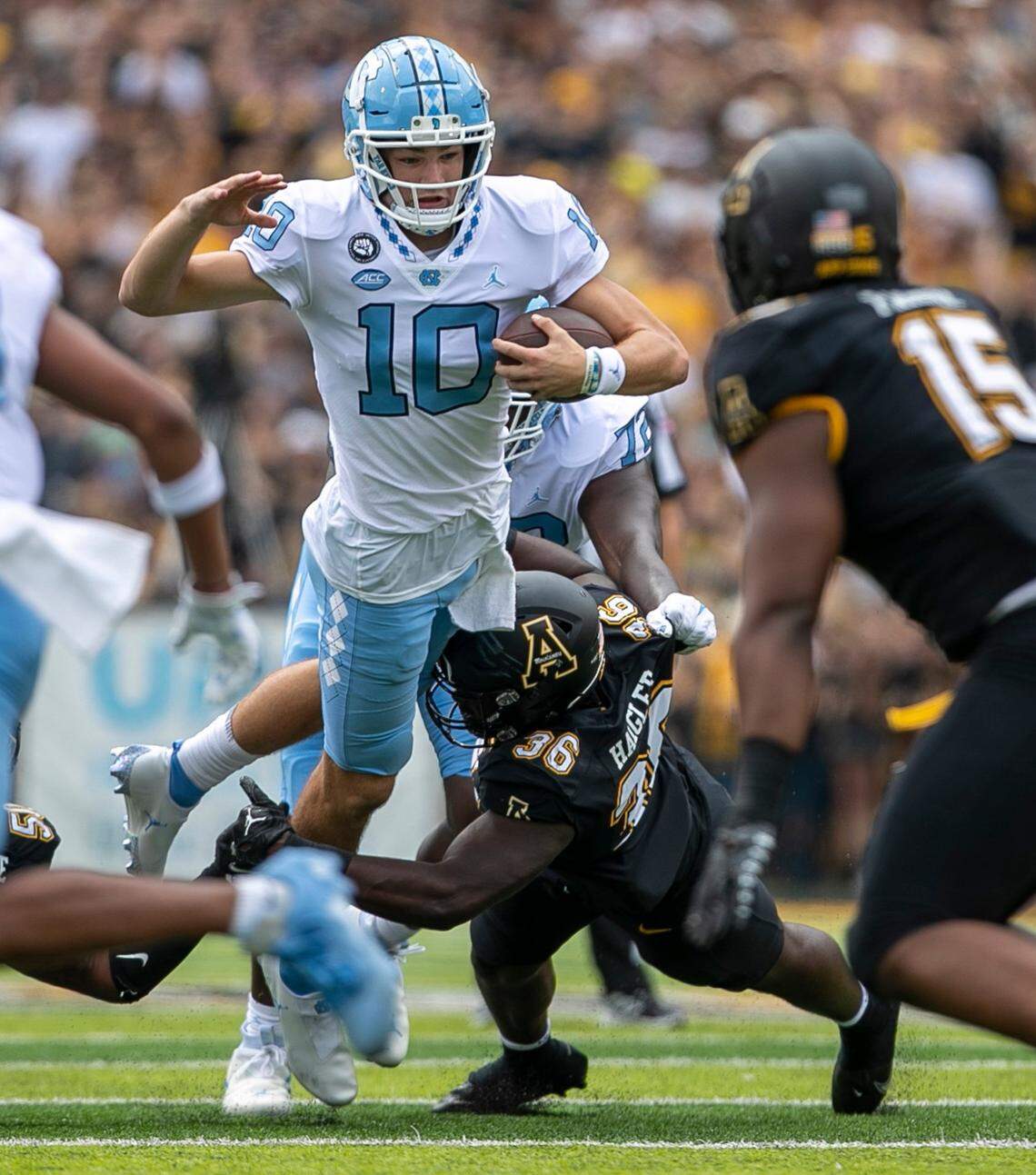 North Carolina quarterback Drake Maye (10) rushes for four yards before being stopped by Appalachian States Kevon Haigler (36) in the first quarter on Saturday, September 3, 2022 at Kidd Brewer Stadium in Boone, N.C.