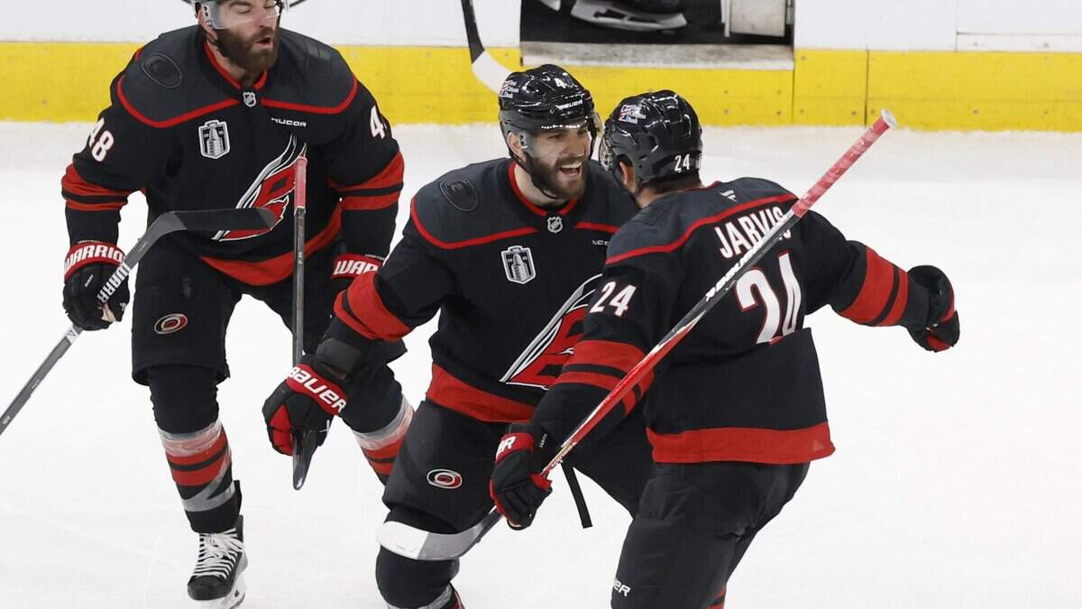 Carolina's Shayne Gostisbehere (center) celebrates with Seth Jarvis after he scored in overtime of the Hurricanes’ 4-3 victory over the Las Vegas Golden Knights in the second game of the Stanley Cup Final at the Lenovo Center in Raleigh, North Carolina, on Thursday, June 4, 2026.