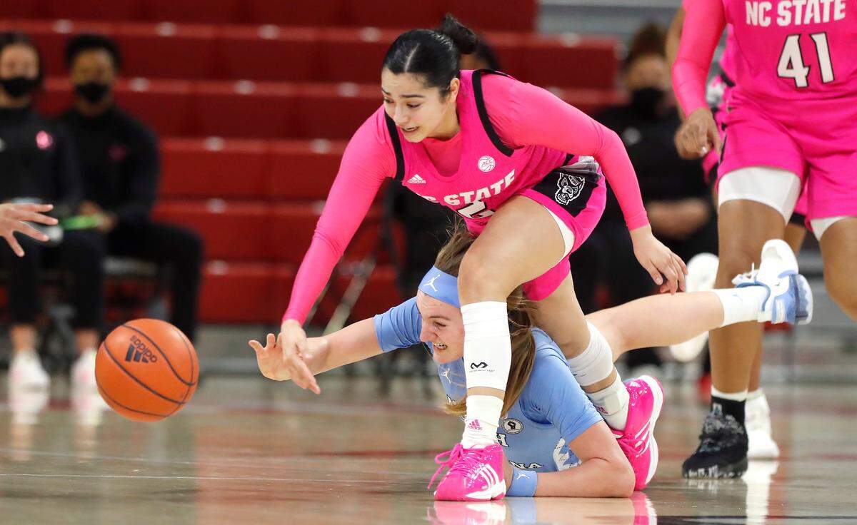 N.C. State’s Raina Perez (2) and North Carolina’s Alyssa Ustby (1) go for the ball after Perez knocked it from the hands of Ustby during the first half of N.C. State’s game against UNC in the annual Play4Kay game at Reynolds Coliseum in Raleigh, N.C., Sunday, February 21, 2021.