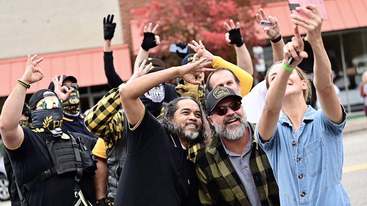 Emily Grace Rainey, a far-right activist from Southern Pines, poses for a selfie with members of the Proud Boys outside a drag show brunch in Sanford on Oct. 30, 2022.