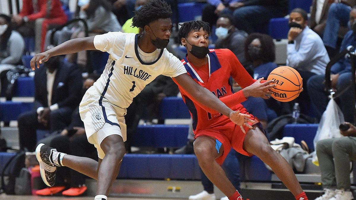 Hillside’s Isiah Riggins (1) attempts the steal against Jordan’s Ronald Bridges (15) during the second half. The Hillside Hornets and the Jordan Falcons met in a conference basketball game in Durham, NC on January 27, 2022. Jordan wins 49-42 in overtime.