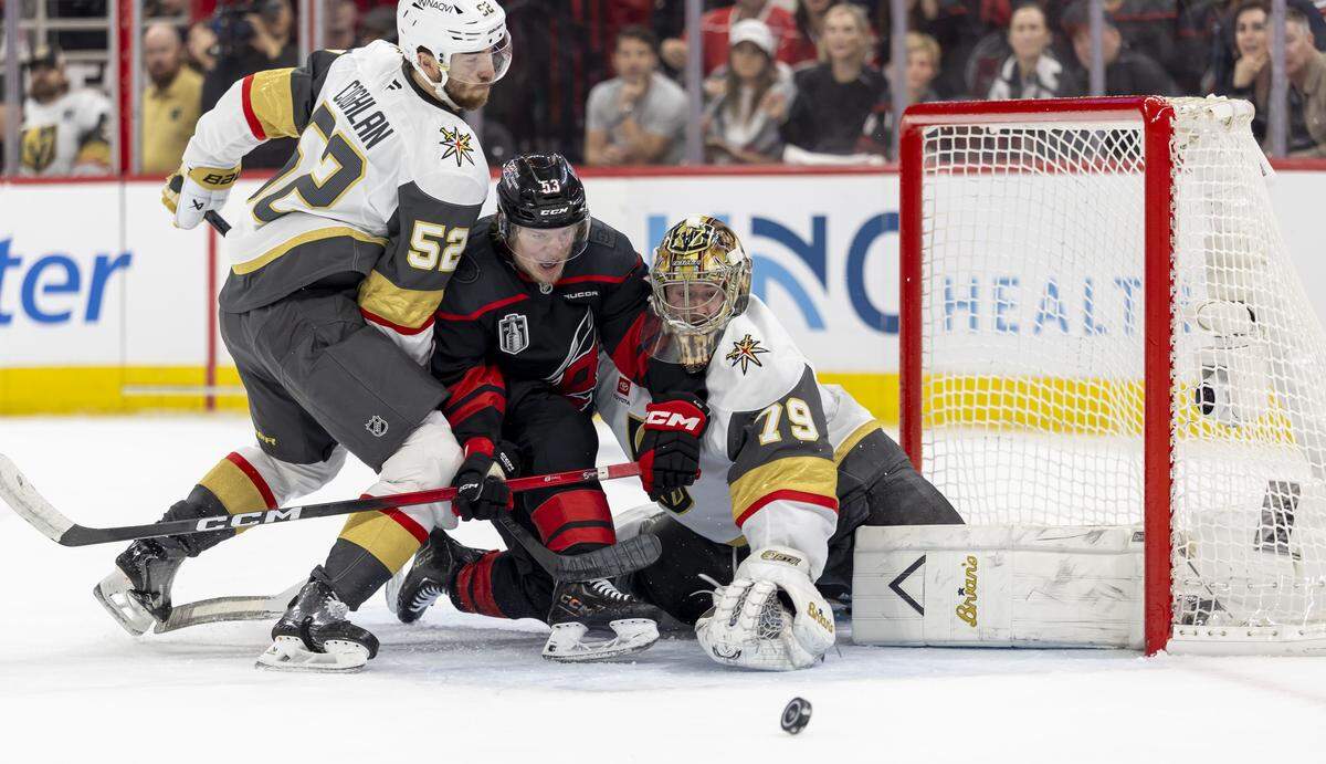 Vegas defenseman Dylan Coghlan (52) defends Carolina Hurricanes right wing Jackson Blake (53) in front of Vegas goalie Carter Hart (79) in the first period in Game 2 of the Stanley Cup Final, on Thursday, June 4, 2026 at Lenovo Center in Raleigh, N.C.