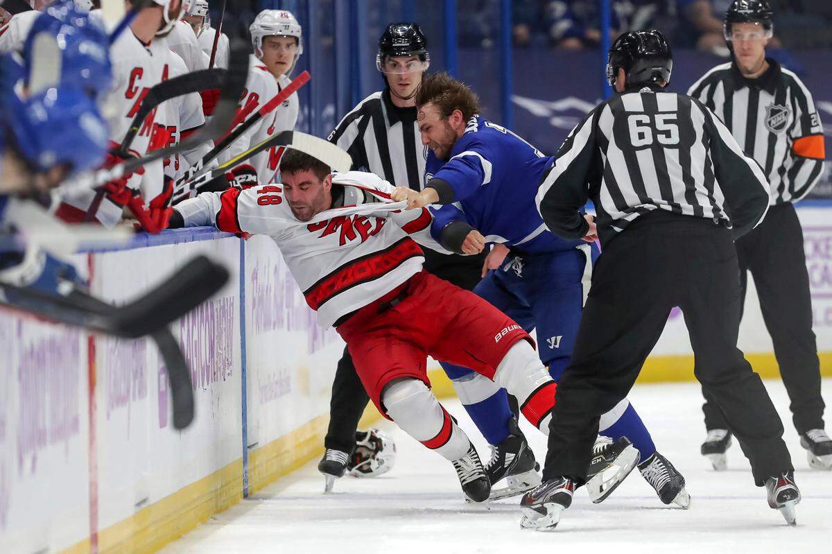 Tampa Bay Lightning’s Barclay Goodrow, right, fights with Carolina Hurricanes’ Jordan Martinook during the second period of an NHL hockey game Tuesday, April 20, 2021, in Tampa, Fla. (AP Photo/Mike Carlson)