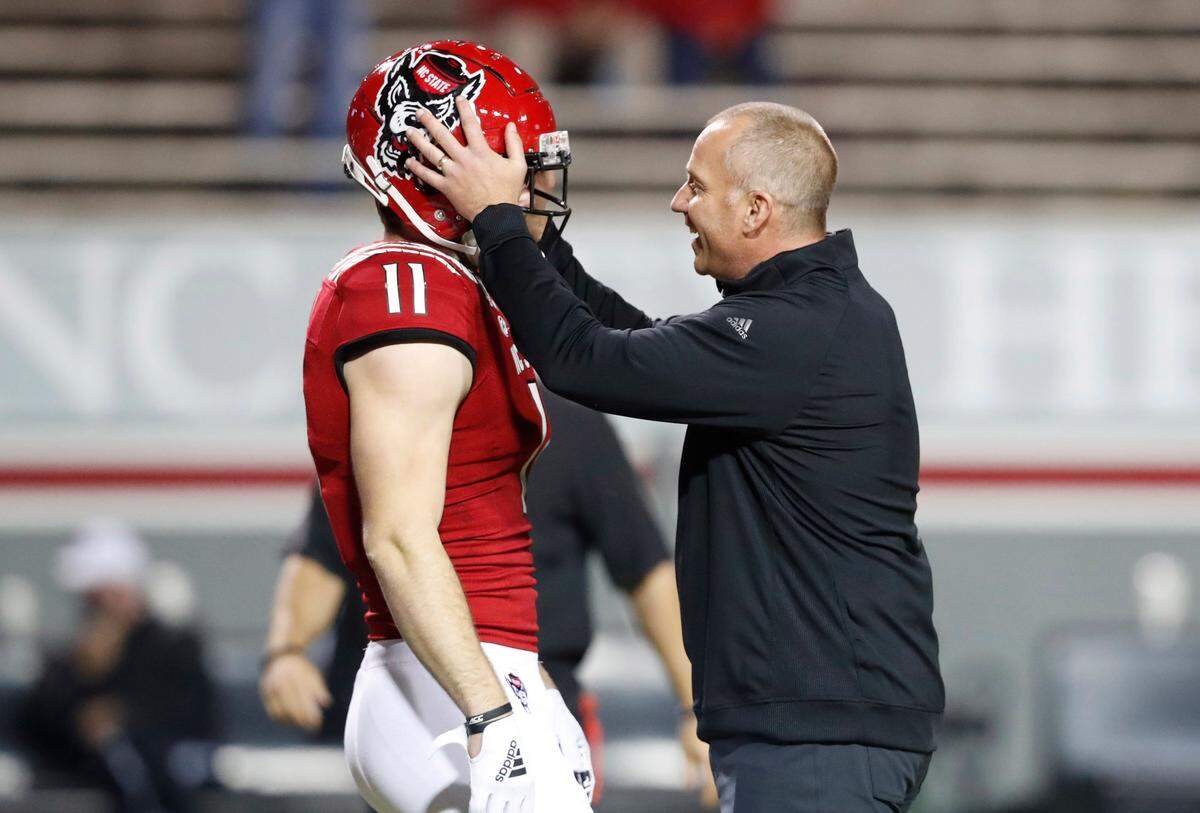 N.C. State head coach Dave Doeren talks with linebacker Payton Wilson (11) before the Wolfpack’s game against Liberty in November 2020.