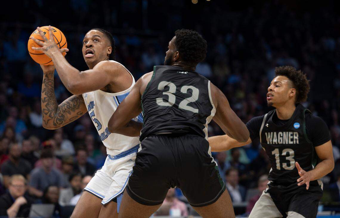 North Carolina’s Armando Bacot (5) works his way to the basket against Wagner’s Keyontae Lewis (32) and Julian Brown (13) in the first half on Thursday, March 21, 2024 during the NCAA Tournament at Spectrum Center in Charlotte, N.C.