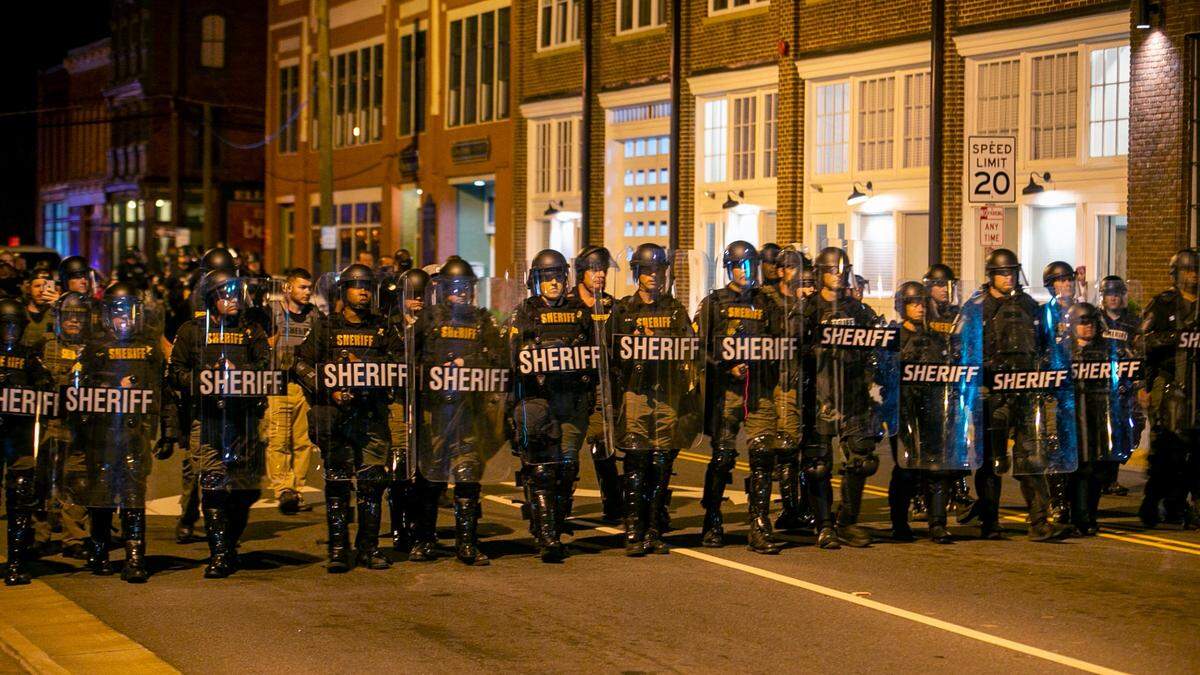 Nearly 100 police and Sheriff deputies in riot gear march on Water Street in downtown Elizabeth City, N.C. just after 11 p.m. on Wednesday, April 28, 2021. Five people arrested for violation of an 8 p.m. curfew one week after Andrew Brown Jr.s death at the hands of Pasquotank County deputies.