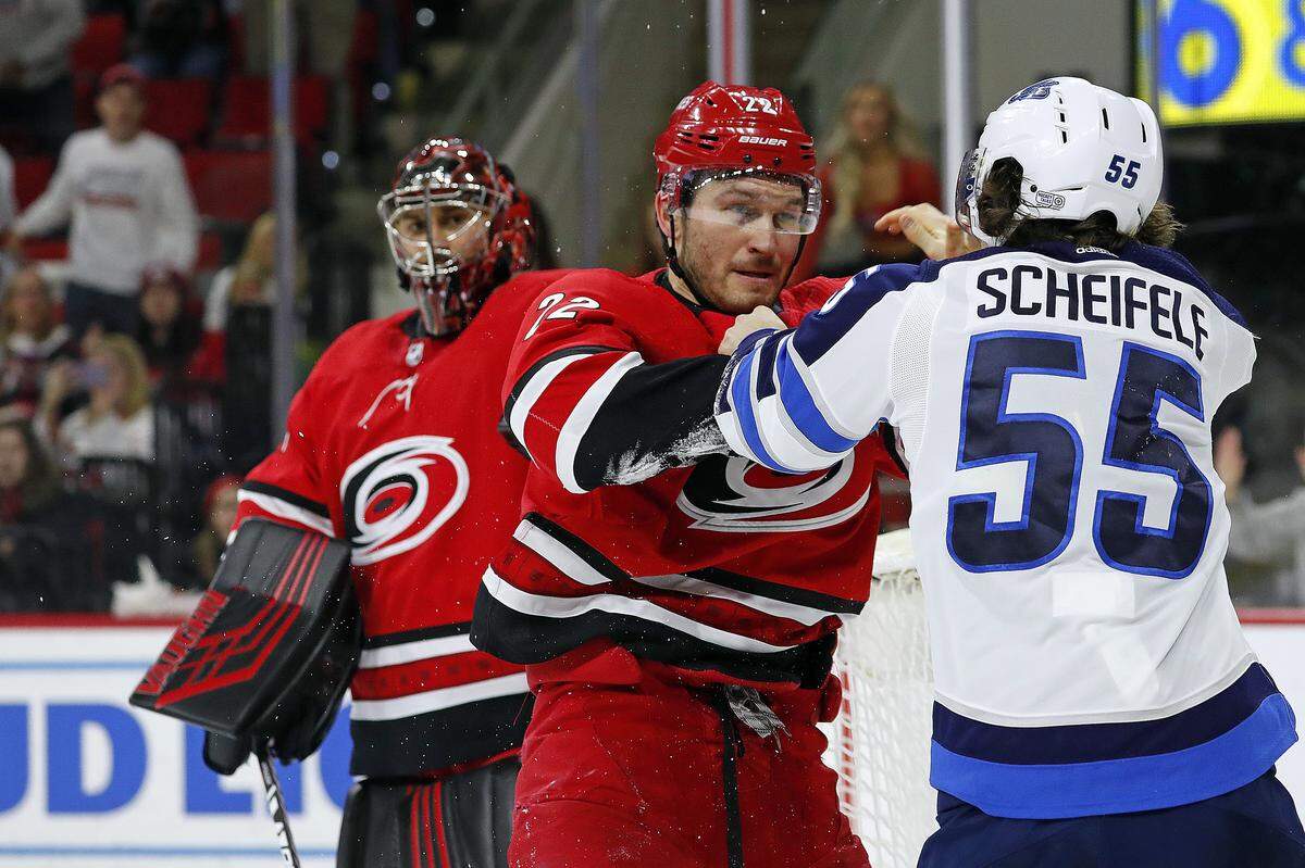 Carolina Hurricanes’ Brett Pesce (22) exchanges blows with Winnipeg Jets’ Mark Scheifele (55) during the third period of an NHL hockey game in Raleigh, N.C., Tuesday, Jan. 21, 2020. (AP Photo/Karl B DeBlaker)