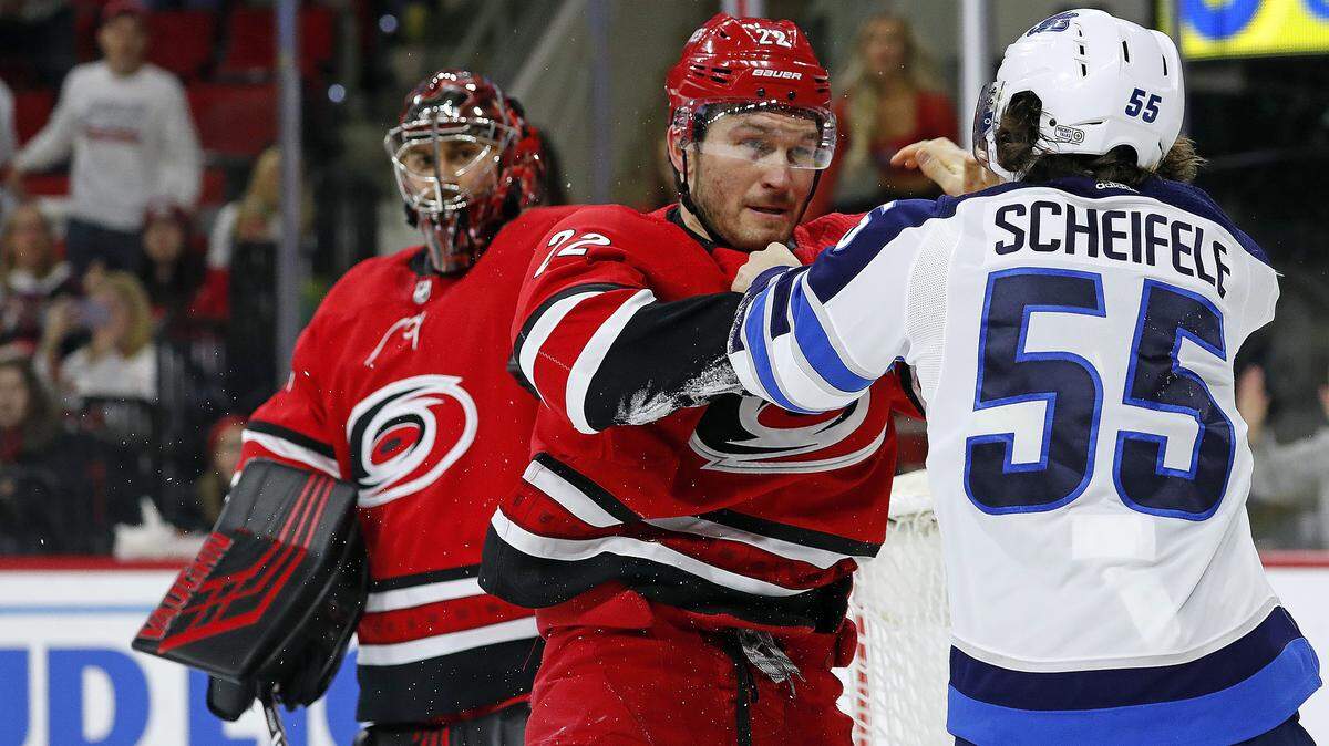 Carolina Hurricanes’ Brett Pesce (22) exchanges blows with Winnipeg Jets’ Mark Scheifele (55) during the third period of an NHL hockey game in Raleigh, N.C., Tuesday, Jan. 21, 2020. (AP Photo/Karl B DeBlaker)