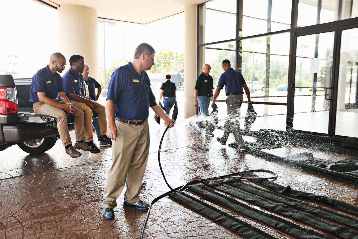 Dan Shank, center, and employees at Southern States Hyundai of Raleigh fill up quick dams to secure the doors of the dealership building in advance of Hurricane Florence on Wednesday, Sept. 12, 2018. 