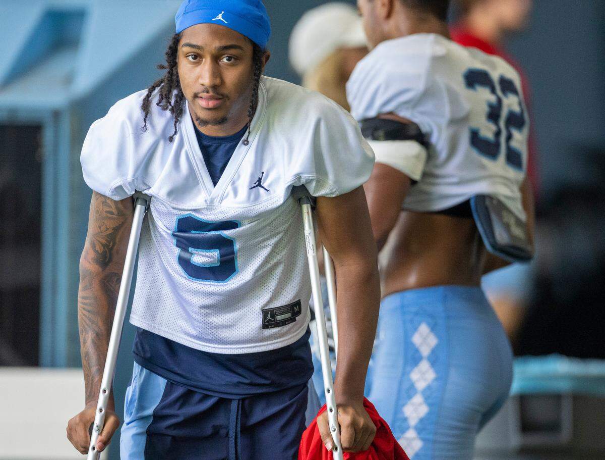 North Carolina defensive back Lejond Cavazos (6) watches his teammates practice as he recovers from an injury on Tuesday, August 8, 2023 in Chapel Hill, N.C. Coach Mack Brown said he expected Cavazos to be out for four to six weeks.