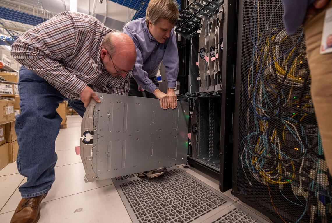 Andrew Wray, senior engineer for high performance computing and Jarrod Johnson, senior software engineer at Lenovo install a server into one of the data center racks at the Lenovo campus in Morrisville, N.C. on Tuesday, January 28, 2025.