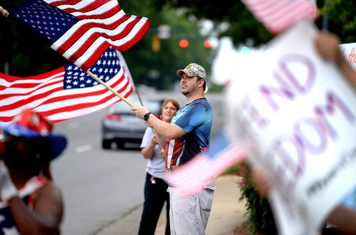James Mallabone of Annapolis, NC participates in a ReOpen NC/Memorial Day rally prepares for the rally with mask and rubber gloves in Charlotte, NC on Monday, May 25, 2020. 