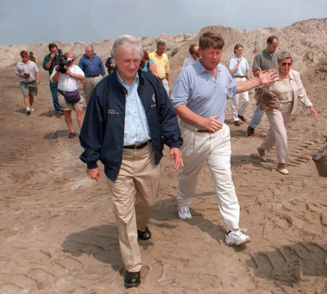 N.C. Gov. Jim Hunt, left, and Sen. Marc Basnightwalk along a buried stretch of NC Hwy. 12 just north of the Outer Banks village of Buxton in 1999 during tour of the hurricane-damaged area.