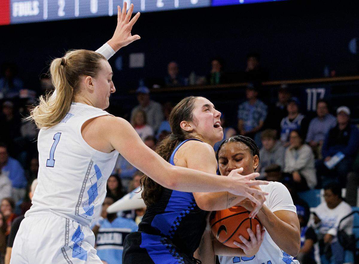 North Carolina’s Alyssa Ustby and Reniya Kelly force a jump ball with Kentucky’s Georgia Amoore during the second half of theTar Heels’ 72-53 win on Thursday, Dec. 5, 2024, at Carmichael Arena in Chapel Hill, N.C.